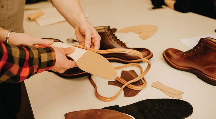 The featured image shows people working with shoe materials.